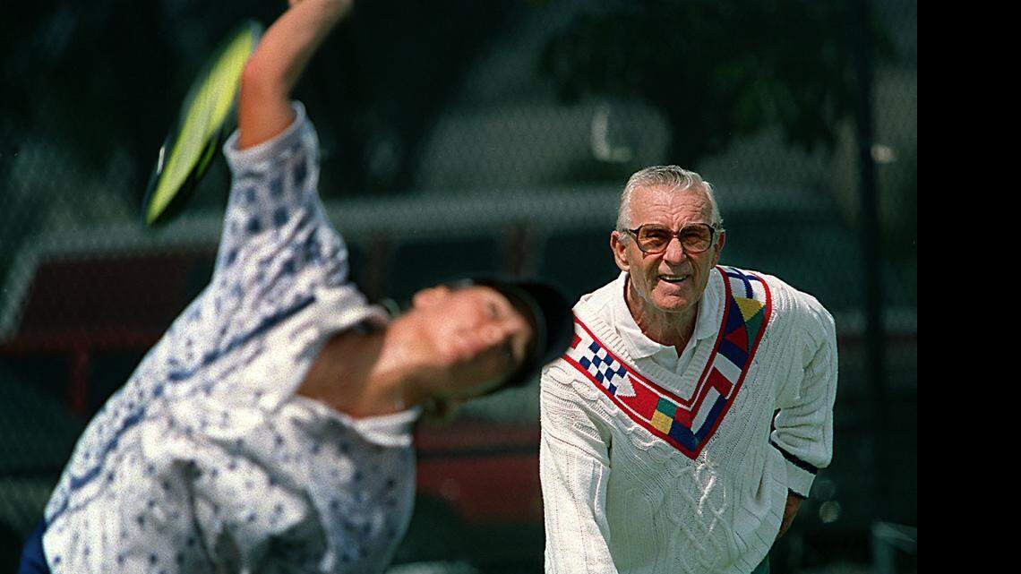 
EAGLE EYE: Saki Balafas would circle magazine photos of superstar tennis players’ racket and body positions so he could have his students at Moore Park in Allapattah and Tennis Villas in West Kendall mirror proper form. Here, in 1996, he watched as Milangela Morales practiced serves during a lesson.
