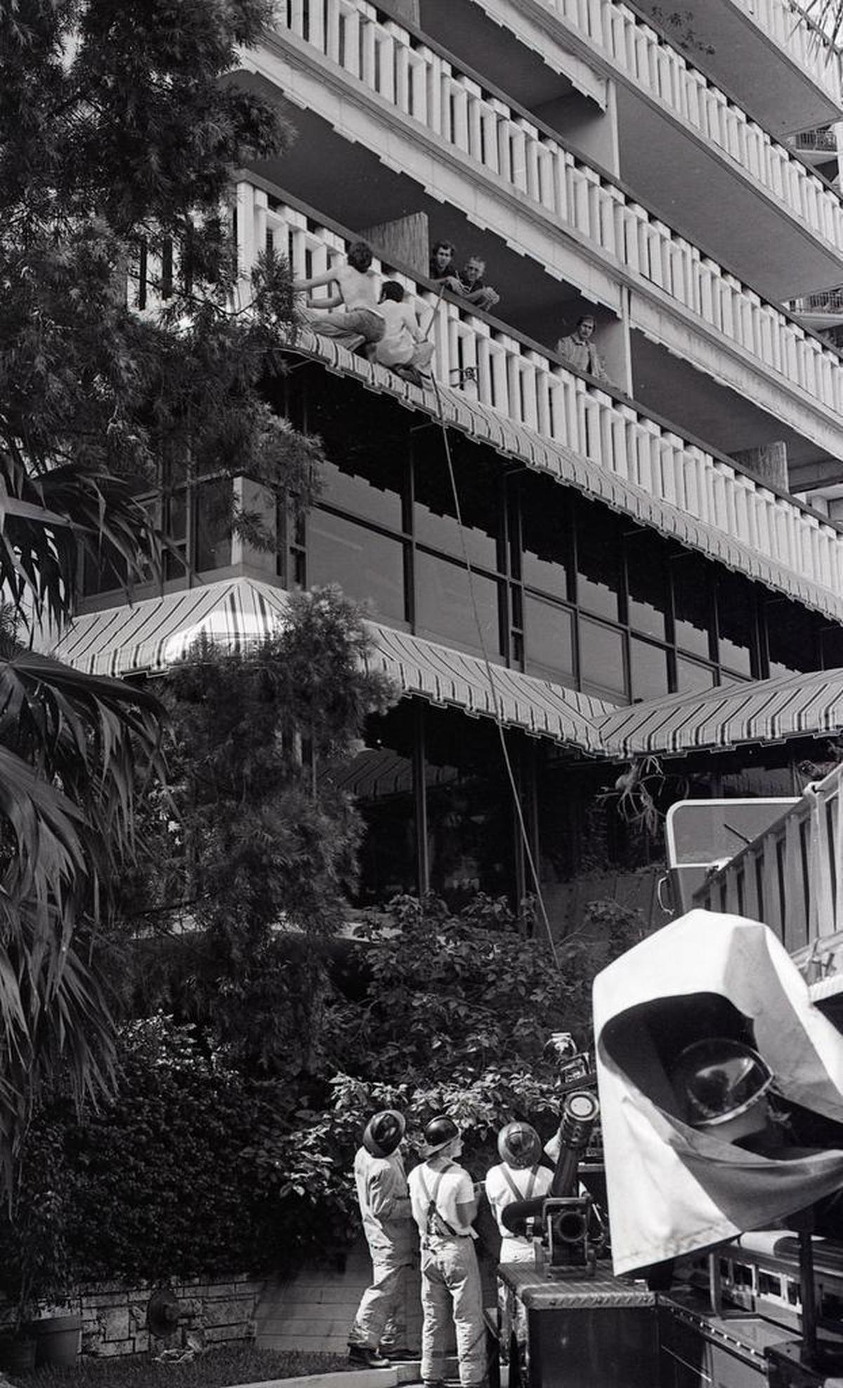 Two men scramble down the side of The Mutiny Hotel in June 1980, balcony to balcony from their 10th floor room into the arms of Miami police. The pair, carrying cocaine, set fire to a stack of bills in the Jacuzzi in Room 1020 and fled when firefighters approached.