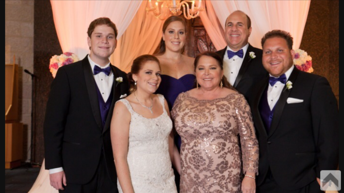 The Marcus family celebrates daughter Sarah’s wedding in December 2015. Elyse Marcus’ health rallied briefly to help put together the wedding for her daughter but afterward complications from cancer arose. Front row, from left: Sarah and her mother, Elyse. Back row: Andrew, Carly, their dad Eddie, and son Michael Marcus.