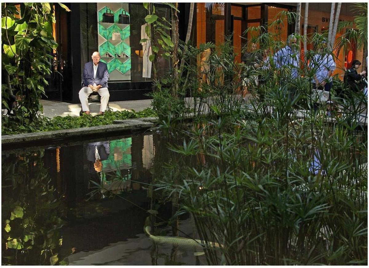Stanley Whitman sits near one of mall’s ponds and green spaces inside his family-owned Bal Harbour Shops in 2013.