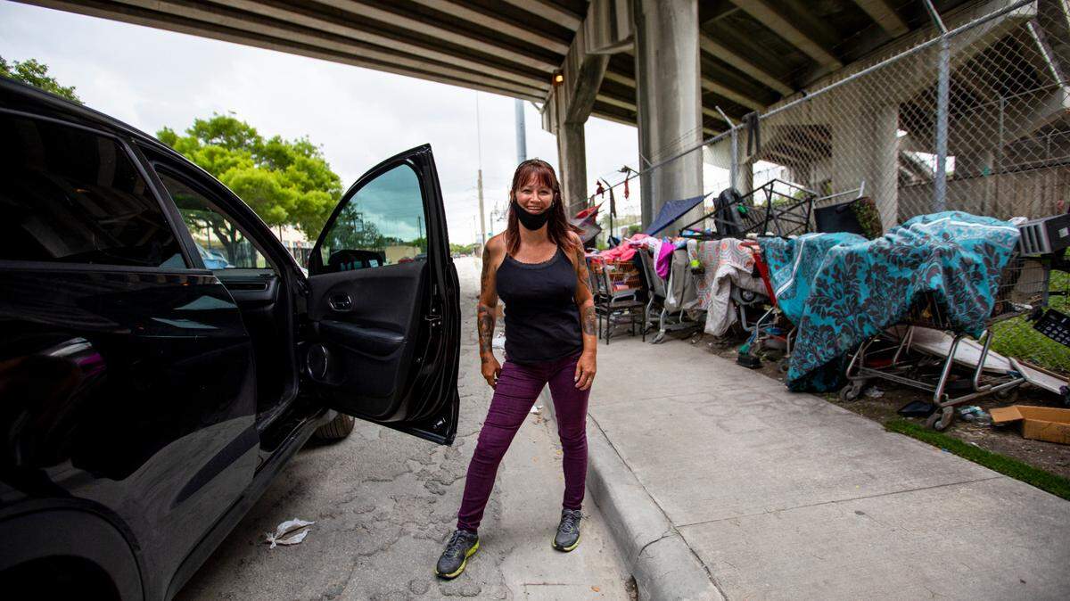 Margo Lawson, 48, smiles for a photo while assisting Miami Herald journalists on assignment while reporting on the opioid crisis underneath I-95 expressway in Overtown in June.