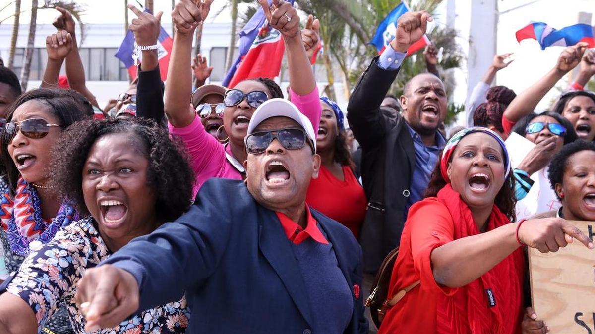 Haitian community members show up in large numbers at the Southern Boulevard bridge on Martin Luther King Jr. Day in West Palm Beach Monday, Jan. 15, 2018, to protest reports of disparaging remarks made by President Donald Trump against Haiti.
