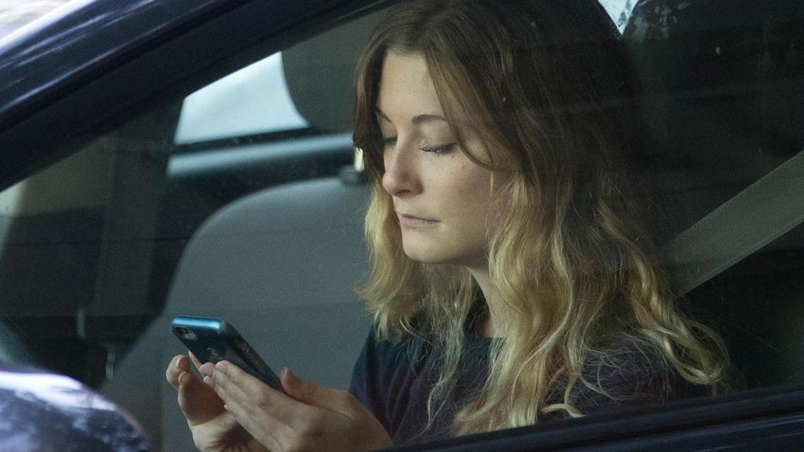 In this 2016 file photo, a driver uses her mobile phone while sitting in traffic in Sacramento, Calif.