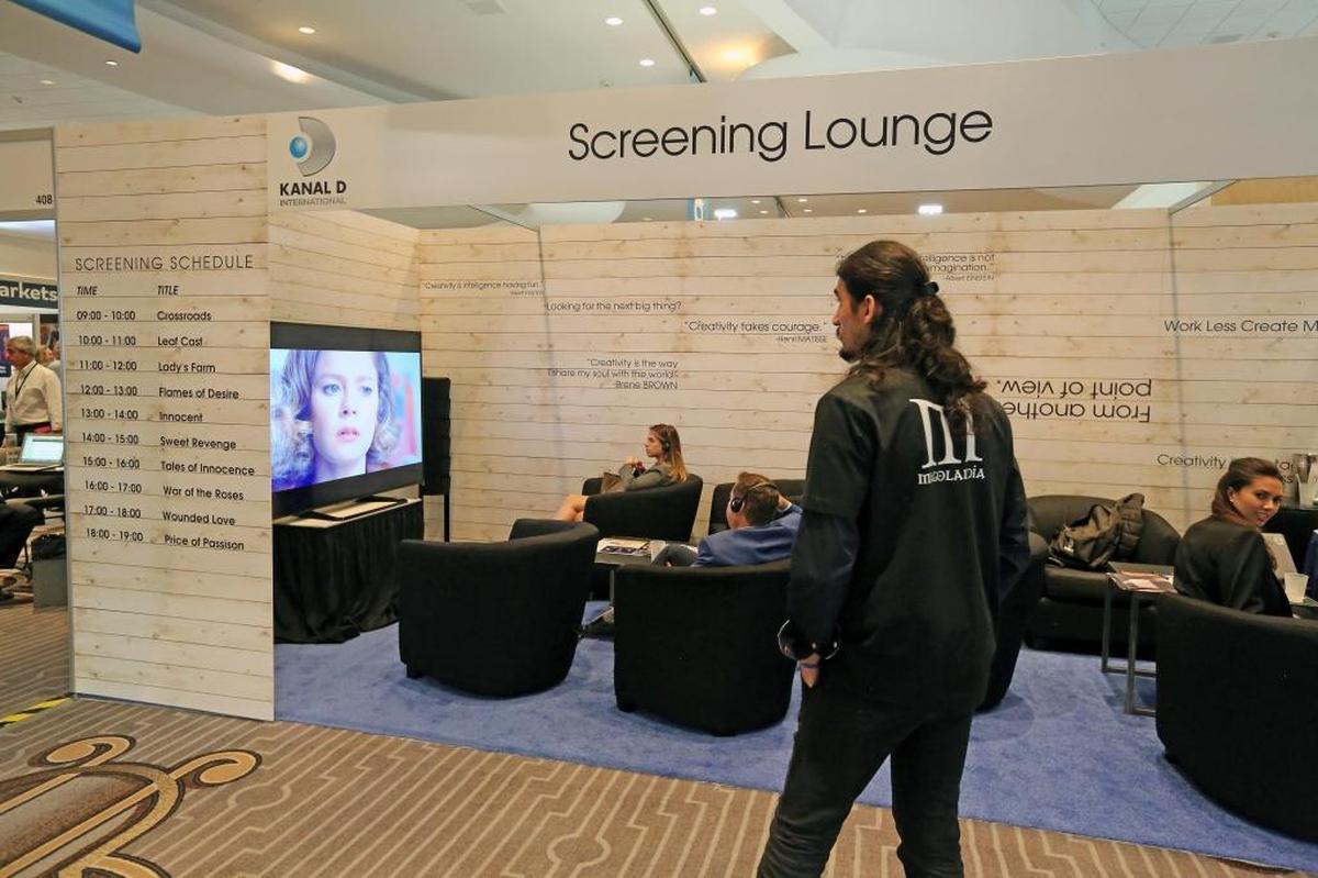 People relax and watch television shows in a screening lounge inside the main floor area at the NATPE convention at the Fontainebleau on Miami Beach.