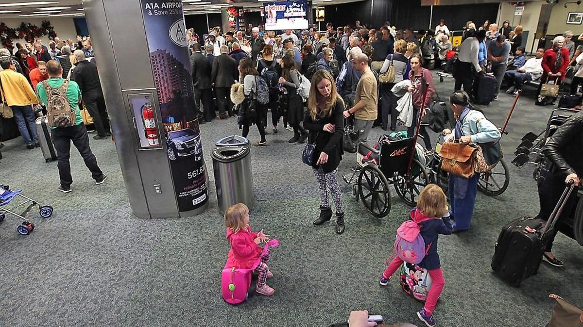 A large crowd gathers around the baggage carousel in Terminal 2 at Fort Lauderdale-Hollywood International Airport on Sunday, Jan. 8, 2017.