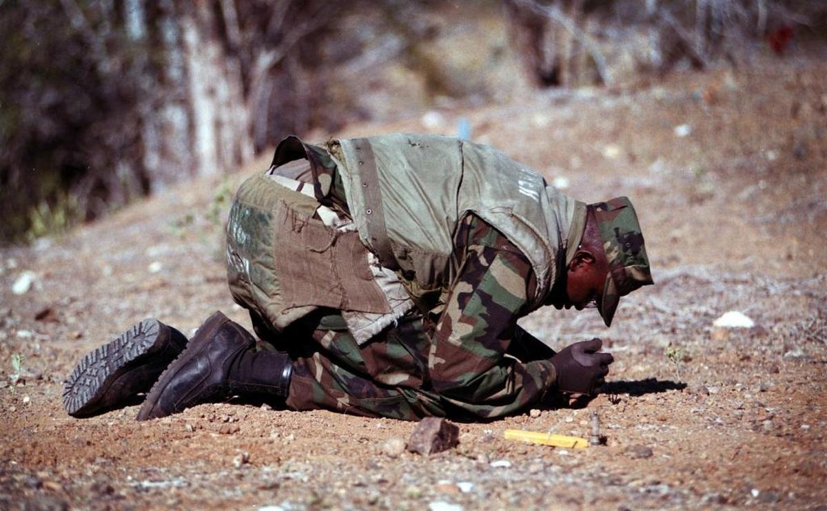 U.S. Marine Staff Sgt. Robert Walker leaning over a dummy mine during a drill at Guantánamo on March 18, 1999.