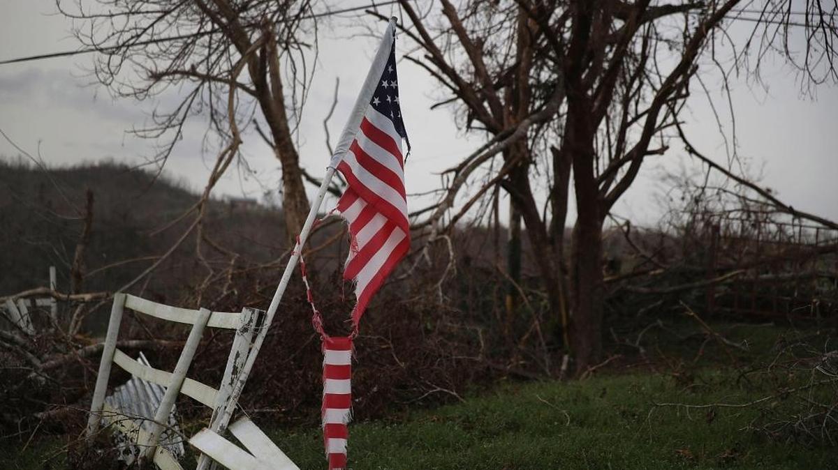 A torn American flag flies from a fence on September 27, 2017 in Morovis, Puerto Rico, from Hurricane Maria’s pass through the area. Puerto Rico experienced widespread, severe damage including most of the electrical, gas and water grids as well as agricultural destruction after Hurricane Maria, a Category 4 hurricane, passed through.