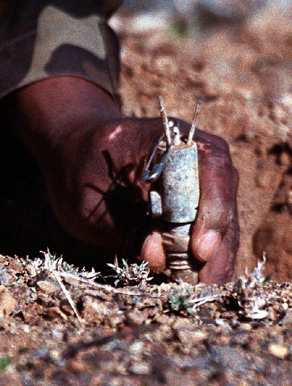 U.S. Marine Staff Sgt. Robert Walker pulls up a practice mine after safely pinning it with a safety pin during a drill at Guantánamo on March 18, 1999.
