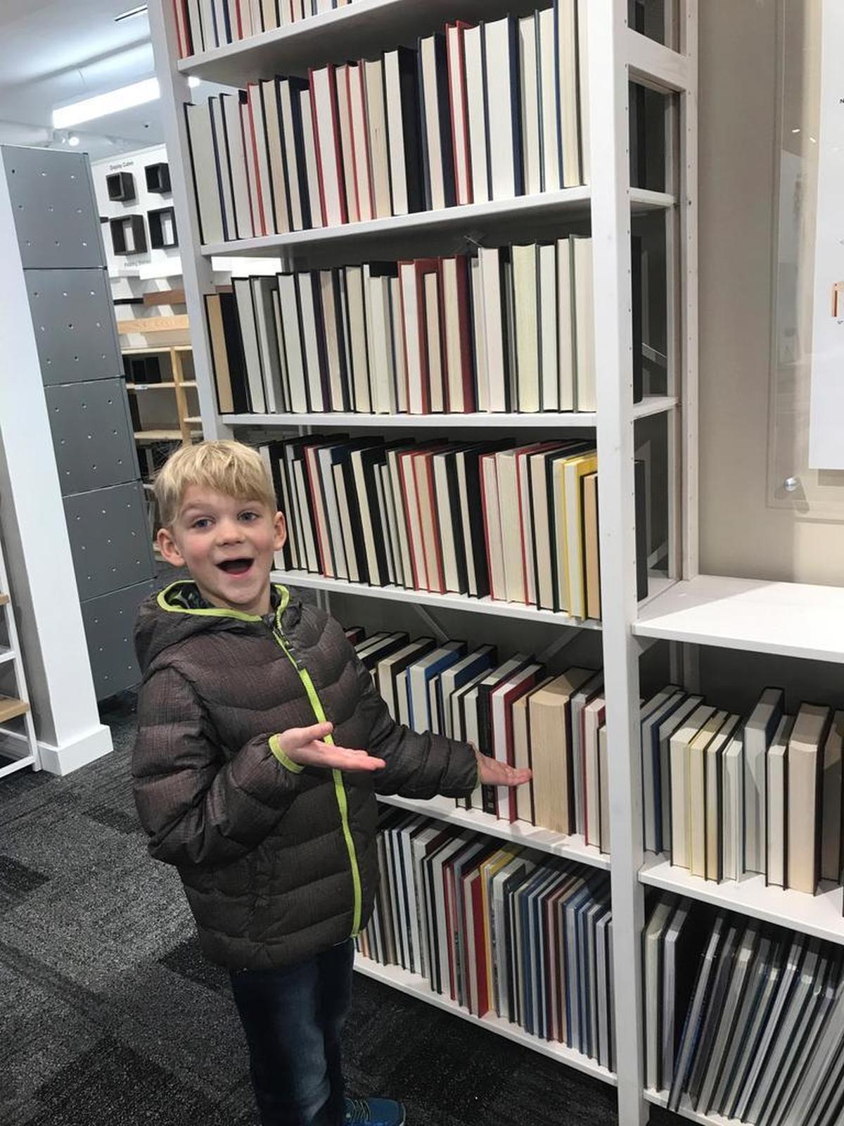 This undated photo shows Oliver Peacock in front of a backward-facing book shelf at The Container Store in Chestnut Hill, Mass. Some big-box retailers have jumped on this design craze for their product displays.