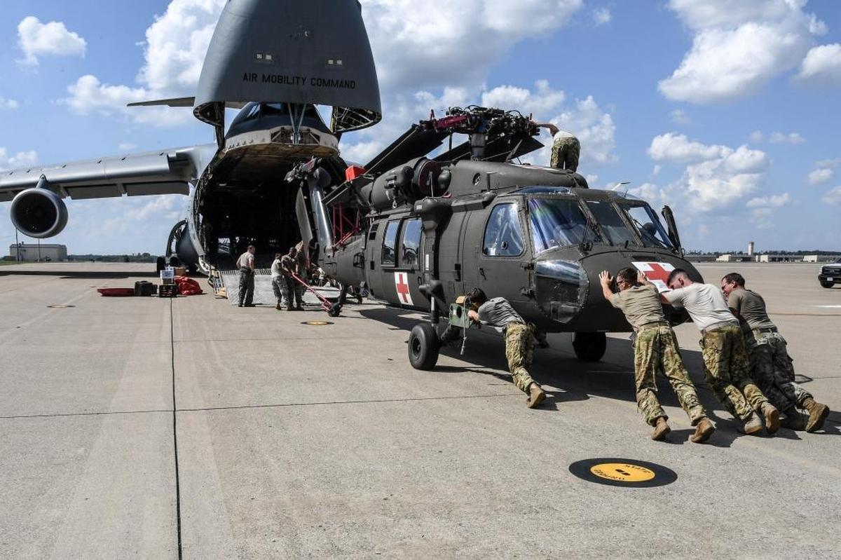 In this Army handout photo from Fort Campbell, Kentucky, soldiers with the 101st Combat Aviation Brigade, 101st Airborne Division and airmen stationed at Travis Air Force Base, Calif., load an HH-60 medevac Blackhawk helicopter on September 26, 2017, into a C-5M Super Galaxy — one of eight choppers that departed for Puerto Rico on September 27, 2017.