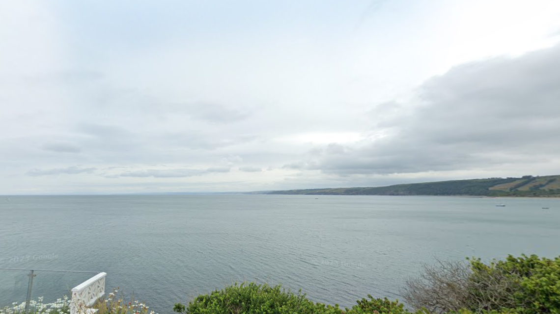 Boaters spotted bottlenose dolphins leaping high out of the water off the coast of England, photos show.