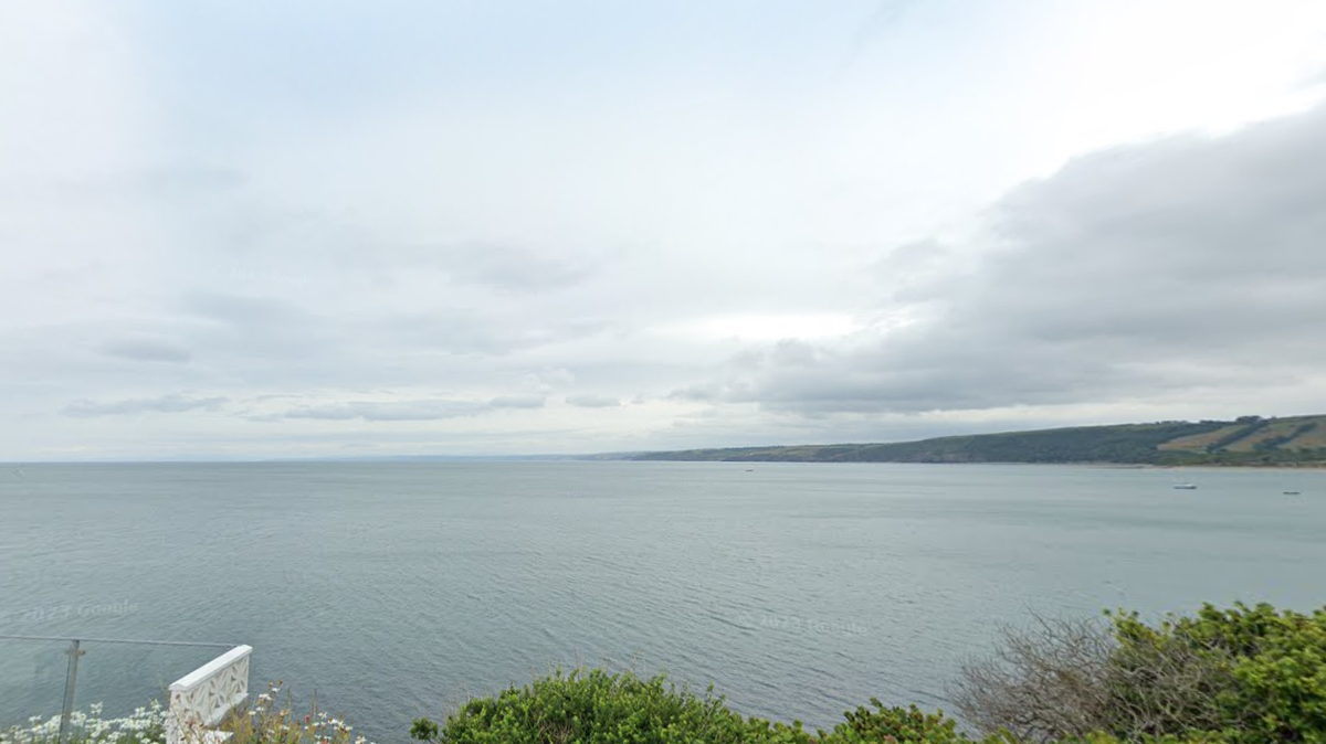 Boaters spotted bottlenose dolphins leaping high out of the water off the coast of England, photos show.