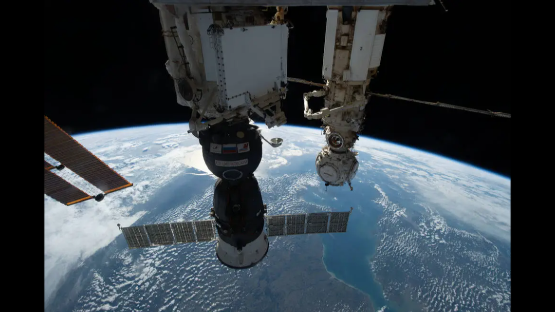 The Soyuz MS-22 spacecraft, in the foreground, suffered a coolant leak due to an external impact and extended cosmonauts’ stay in space, Russian and American space agencies say.