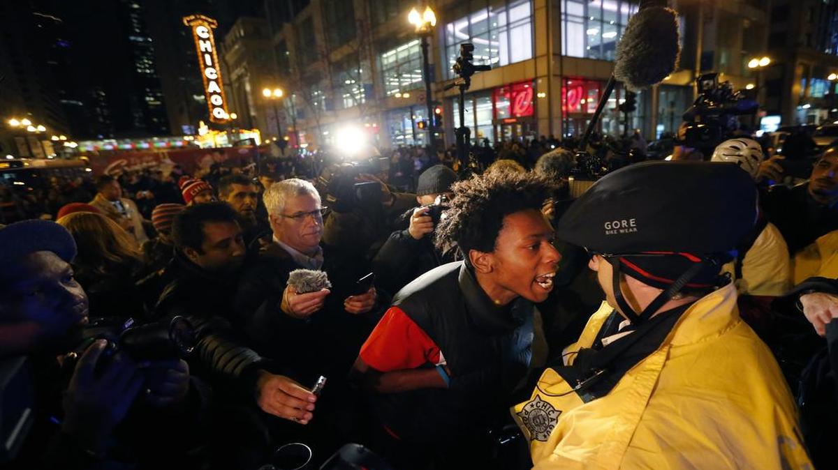 Lamon Reccord, second from right, yells at a Chicago police officer “Shoot me 16 times” as he and others march through Chicago’s Loop one day after murder charges were brought against police officer Jason Van Dyke in the killing of 17-year-old Laquan McDonald, in Chicago.