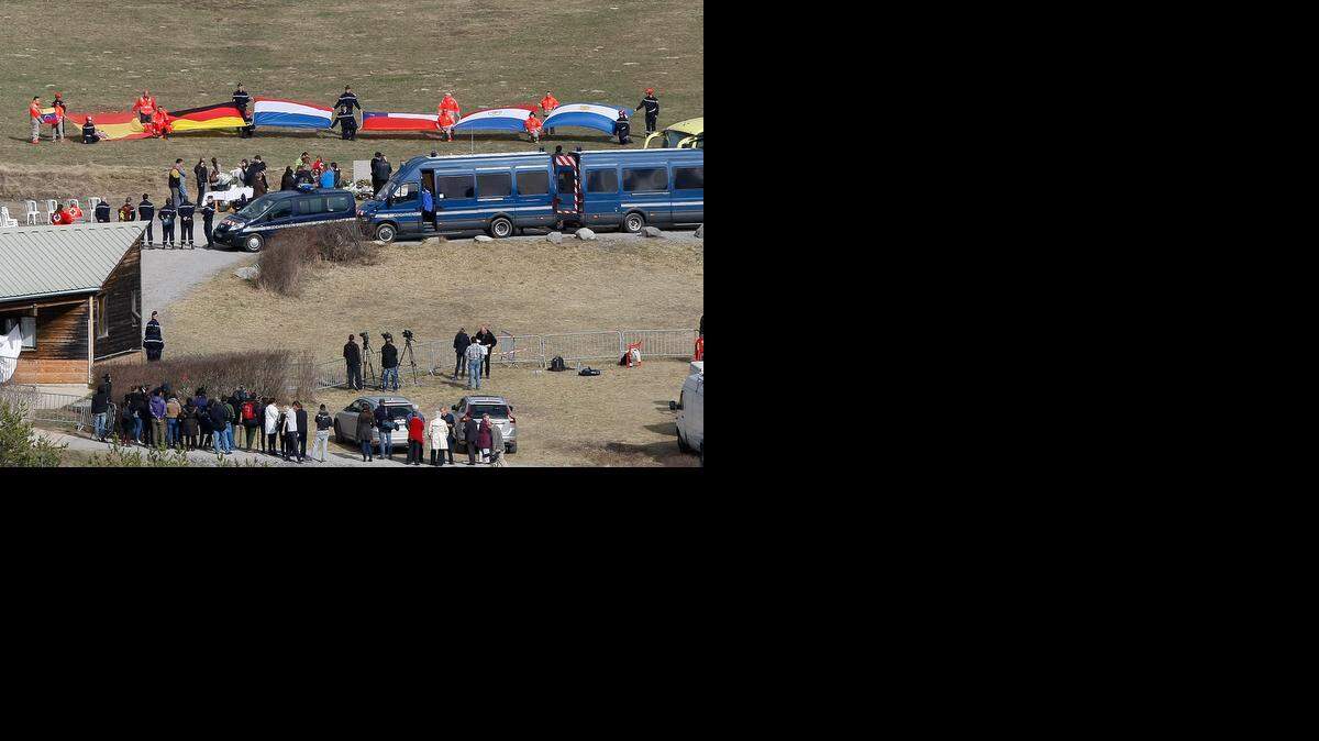 
Flags representing different nations are deployed during an homage ceremony with family members of victims in front of a stone slab erected as a monument, in the area where the Germanwings jetliner crashed in the French Alps, in Le Vernet, France, Sunday, March 29, 2015. The crash of Germanwings Flight 9525 into an Alpine mountain Tuesday killed all 150 people aboard, and has raised questions about the mental state of the co-pilot. Authorities believe the 27-year-old German deliberately sought to destroy the Airbus A320 as it flew from Barcelona to Duesseldorf. 
