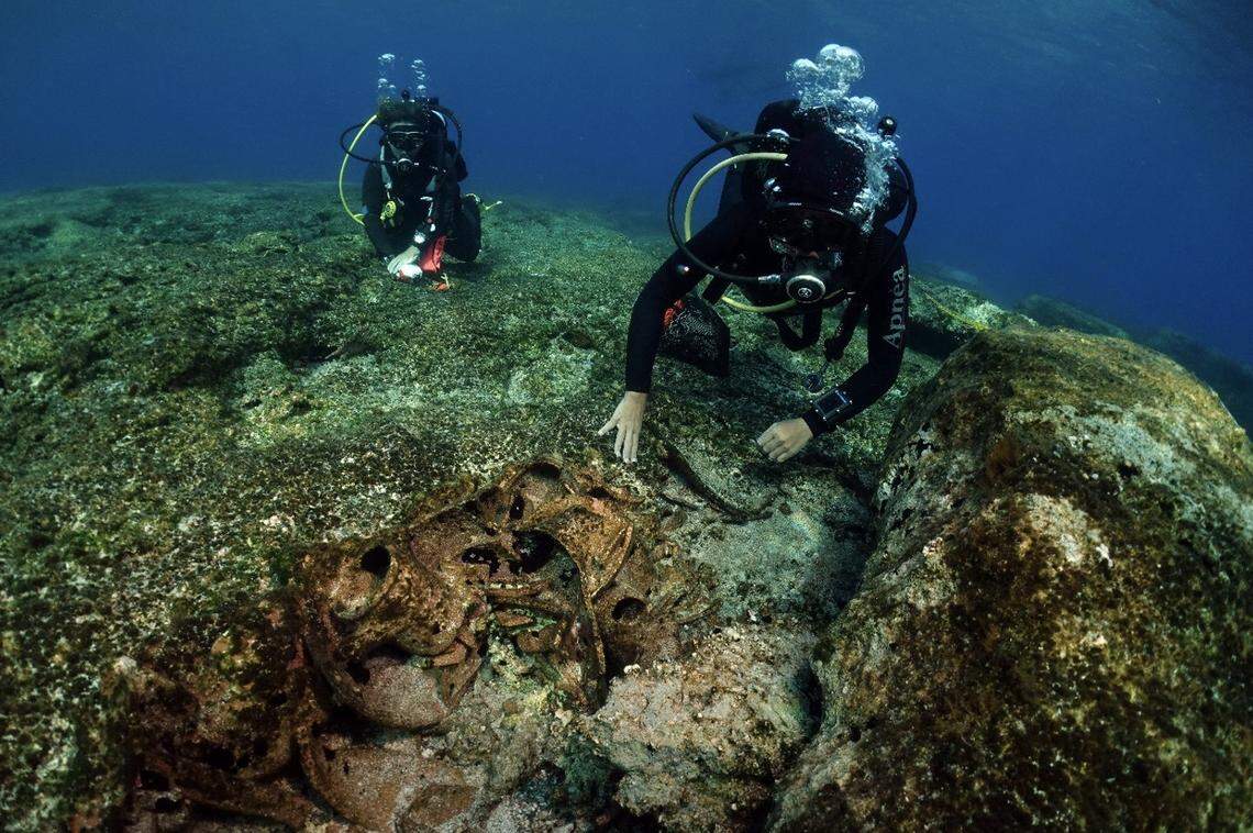 Divers examine underwater artifacts