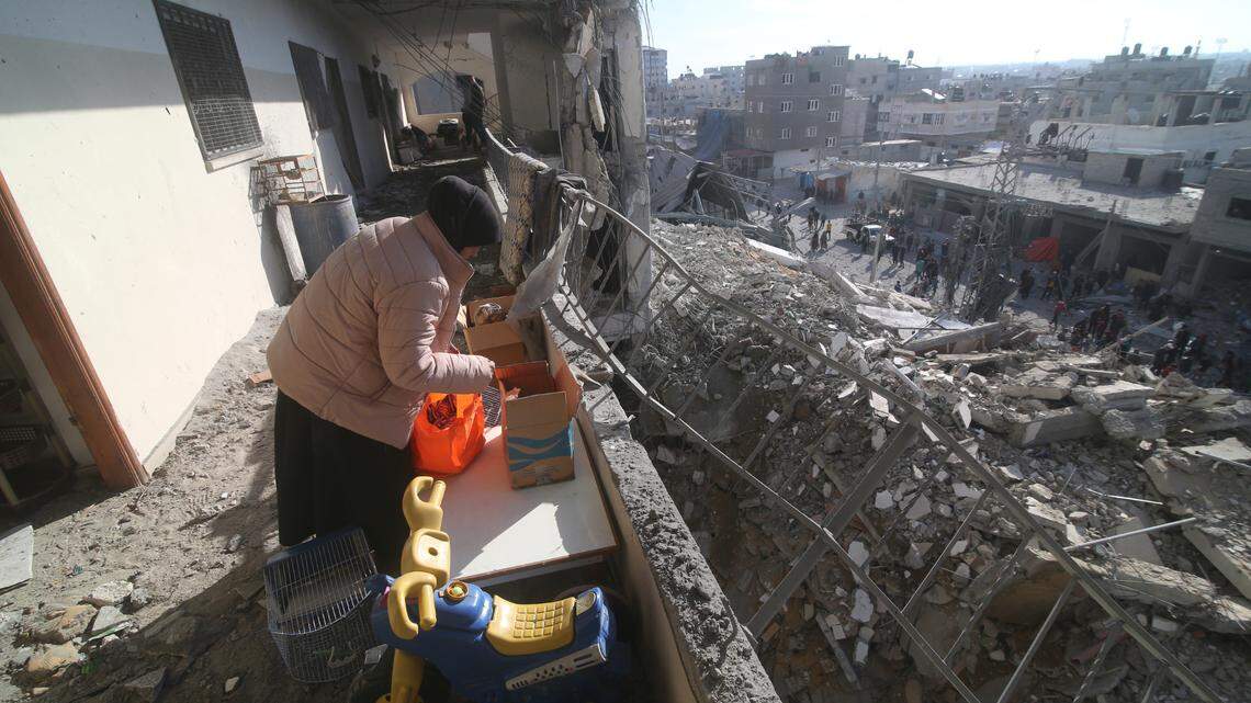 A Palestinian woman cleans up after a residential building was destroyed in an Israeli strike in Rafah, Gaza Strip, Saturday, March 9, 2024.