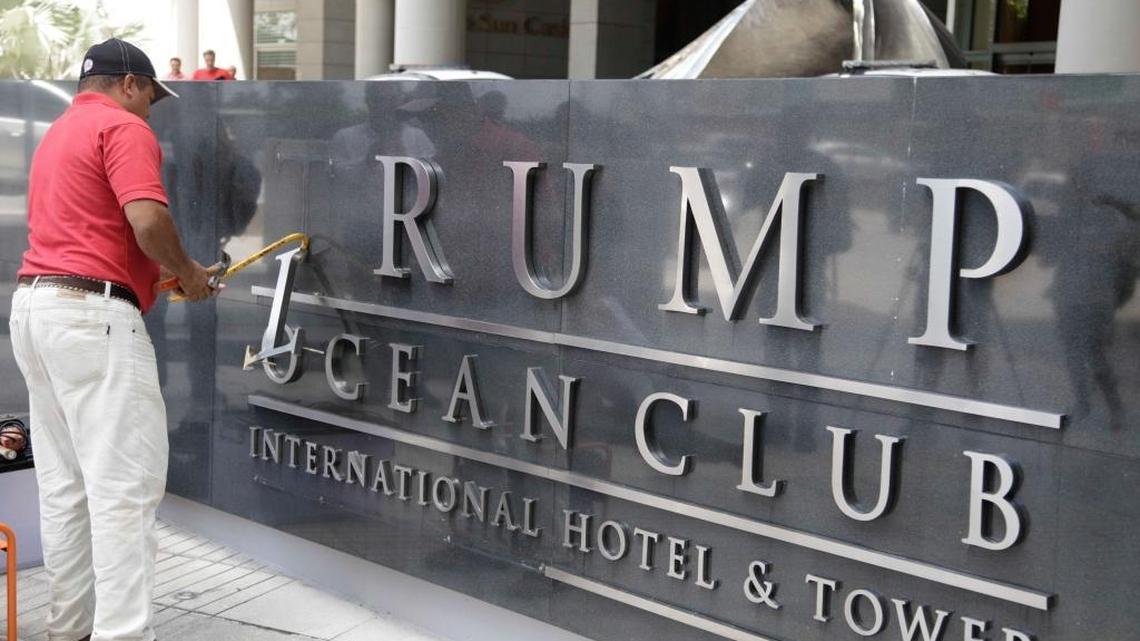 A man removes the word Trump from a marquee outside the Trump Ocean Club International Hotel and Tower in Panama City, Monday, March 5, 2018. By the end of the week the hotel had a new name, The Bahia Grand Panama.