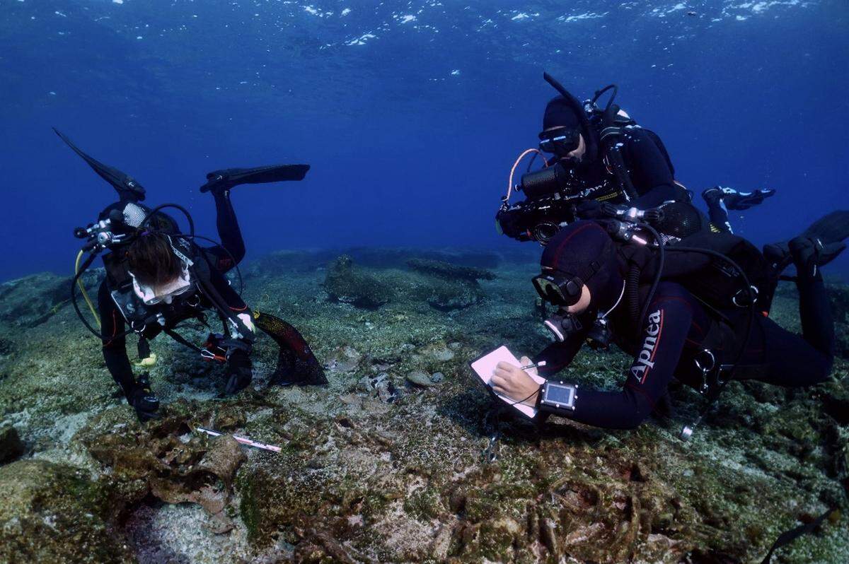 Divers photograph and record underwater artifacts