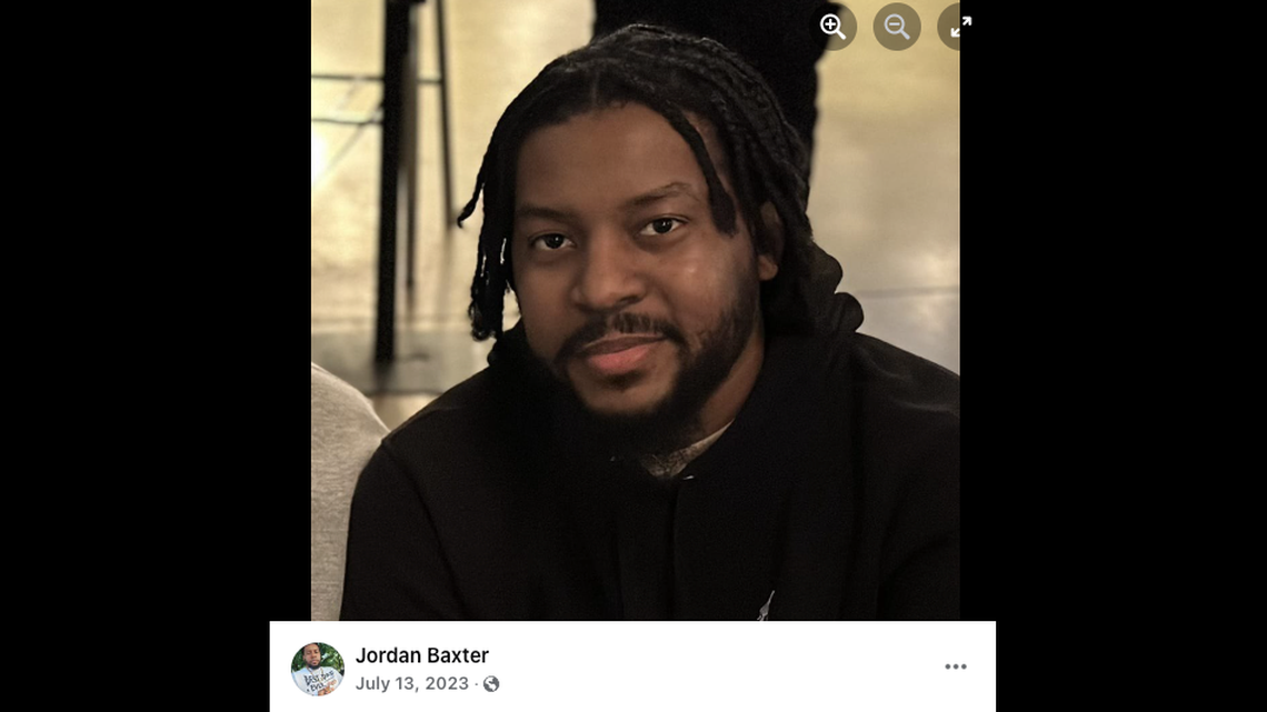 Jordan Baxter, 38, was found dead between two parked cars, authorities say. His wife is charged with murder.