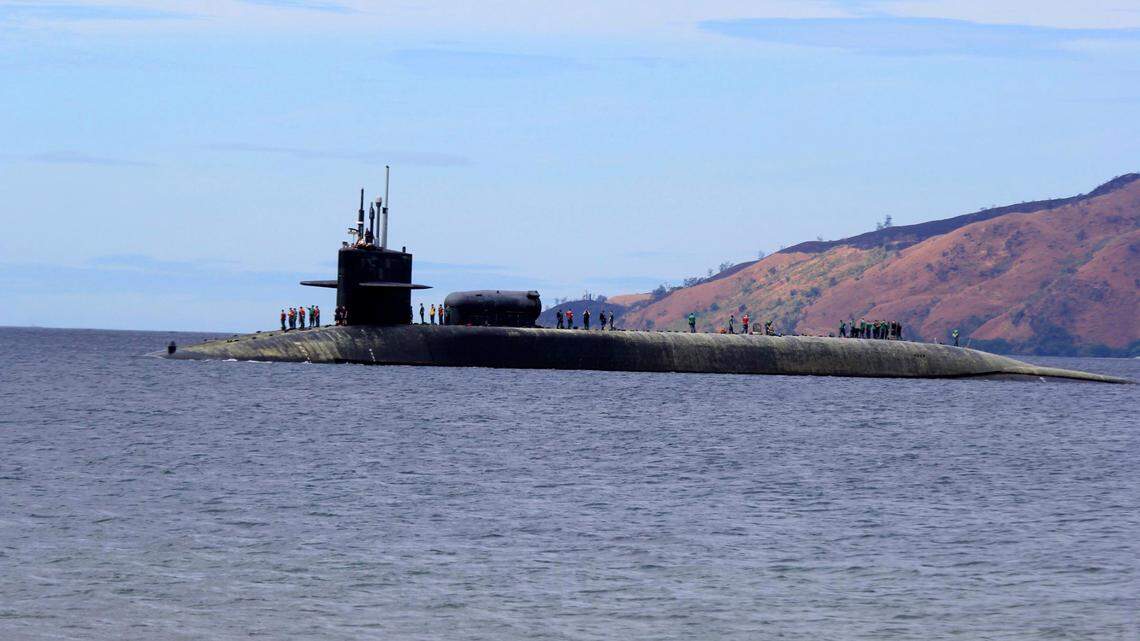 U.S. Navy crew stand on the USS Michigan (SSGN-727), an Ohio-class guided missile submarine, as it prepares to dock at Subic Freeport, a former US naval base Tuesday, March 25, 2014 about 70 kilometers (44 miles) west of Manila, Philippines. (AP Photo/Jun Dumaguing)