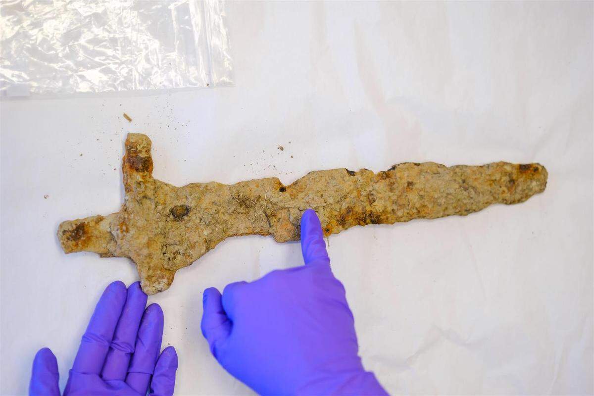 An archaeologist handles the 1,000-year-old Viking sword.