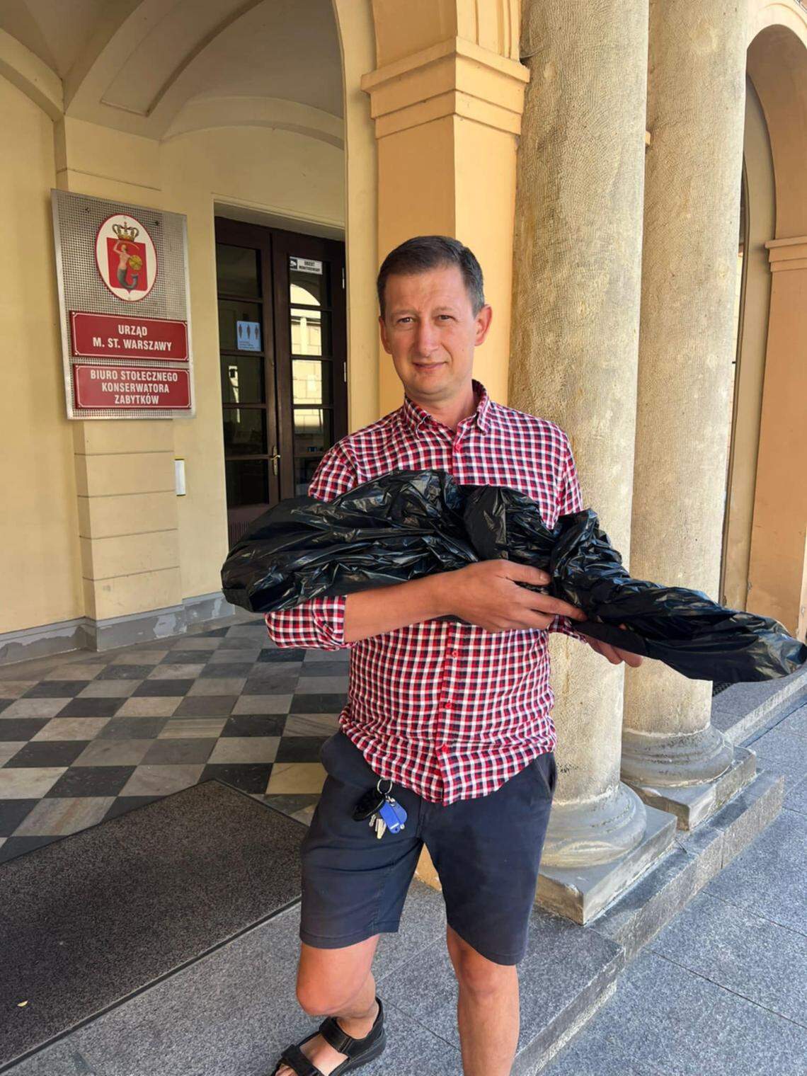 The finder, Andrzej Korpikiewicz, holds the wrapped up sword.