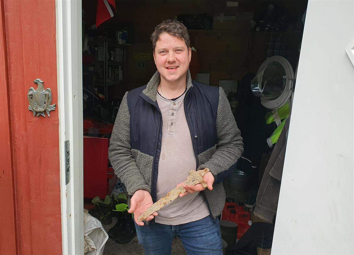 The finder, Øyvind Tveitane Lovra, holds the 1,000-year-old sword.