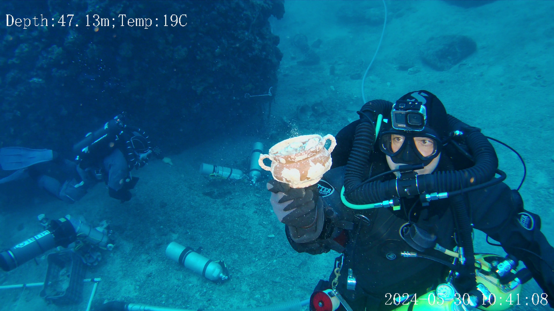 Archaeologists and divers excavated the 2,000-year-old Antikythera wreck and found hundred of artifacts and a wooden ship’s hull, photos show.