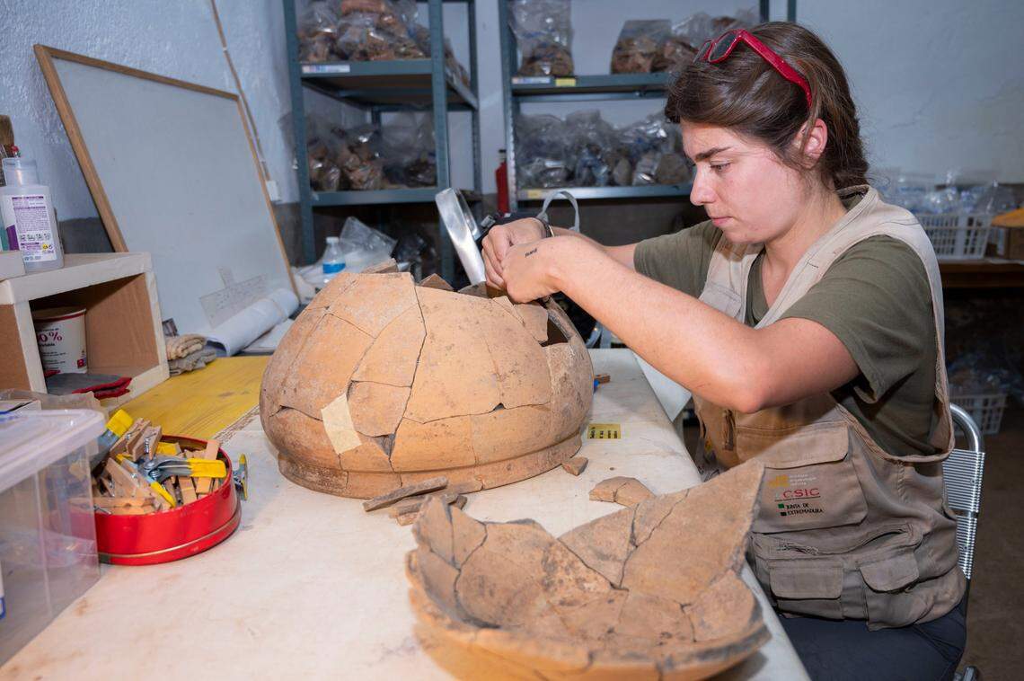 An archaeologist reconstructs a pot from fragments found at the Casas del Turuñuelo.