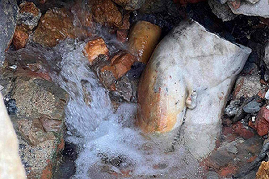 A fragment of the statue still partially submerged.