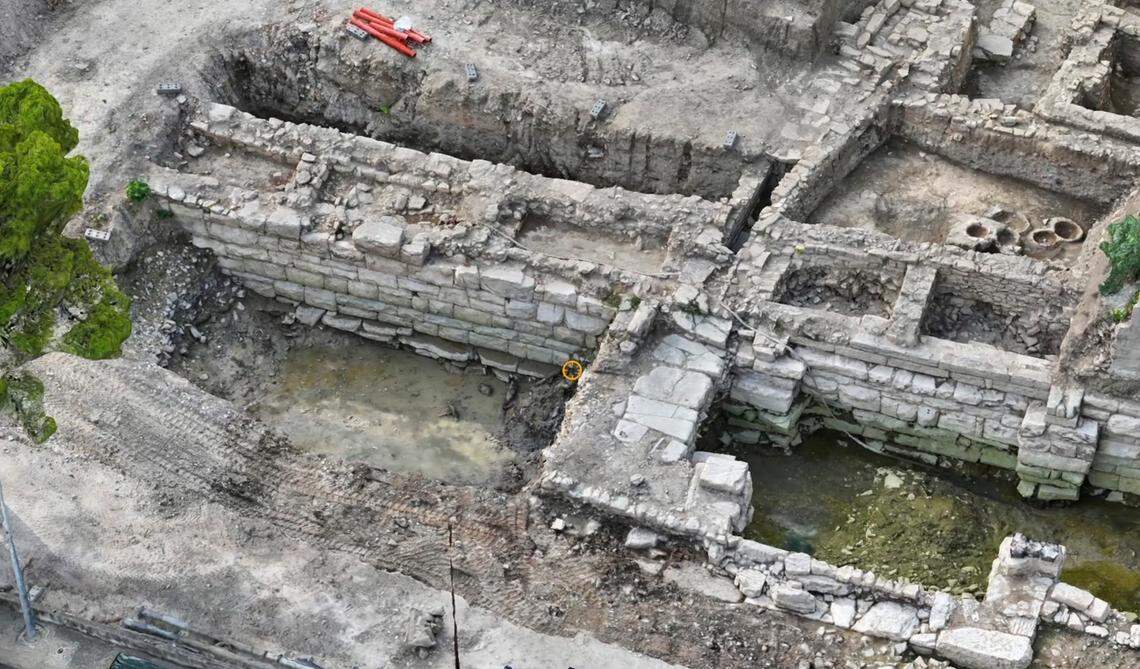 A close-up photo shows the ancient Greek structure.