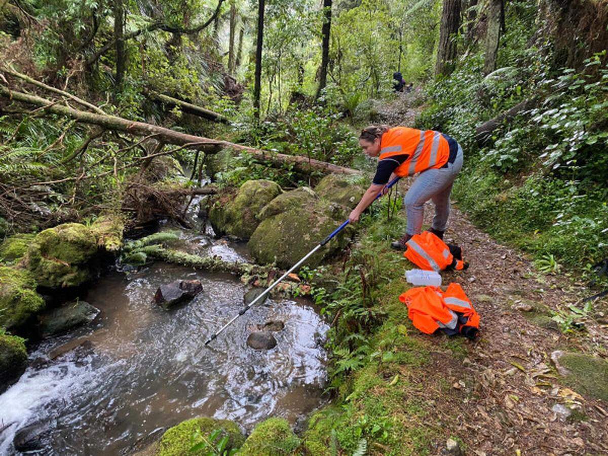 An official samples the water in a nearby part of the river.