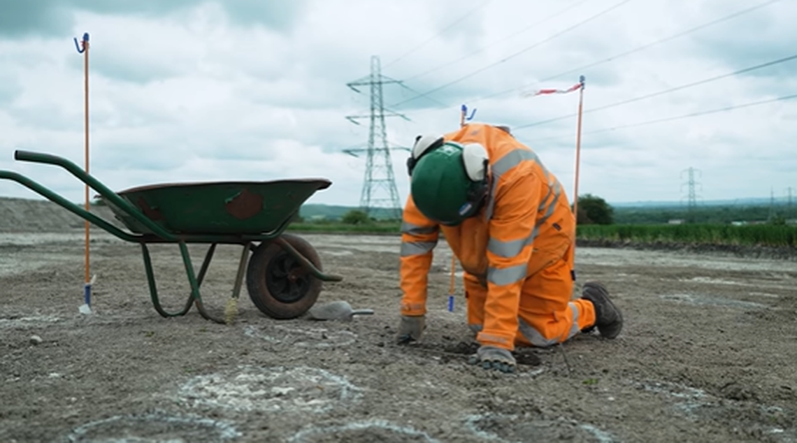 Pole holes of roundhouses, marked by white circles on the ground, belonged to four separate buildings, archaeologists said.