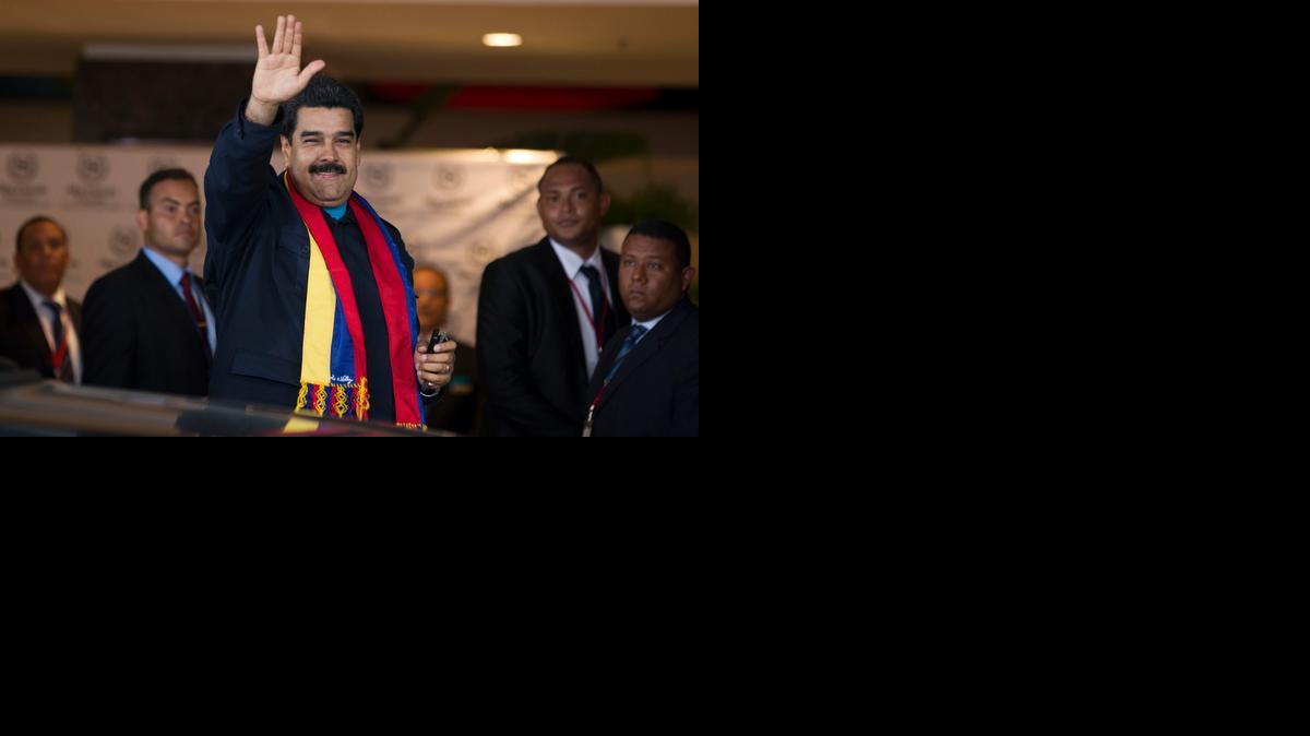 
Venezuela's President Nicolas Maduro waves to photographers as he arrives to a hotel in Panama City, Friday, April 10, 2015. Maduro, who is in Panama to attend the Summit of the Americas, had barely gotten off his plane before he gave a symbolic poke in the eye to Washington, paying a visit to a monument honoring victims of the 1989 U.S. invasion of Panama.
