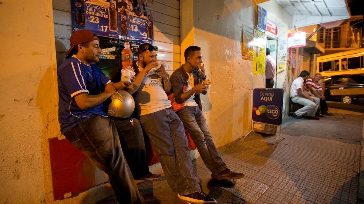 Edgar Diaz, Danny Flores and Josue Cerna eat burgers made by former gang member — Jess “Chuy” Lanza,—who has turned a thousand dollars in USAID seed money into a successful downtown hamburger business in Tegucigalpa, Honduras.