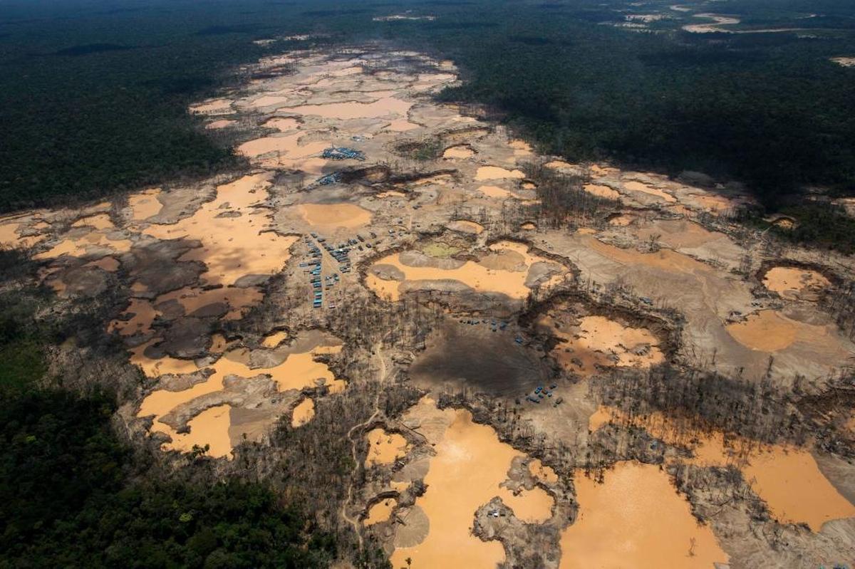 This 2014 photo shows a deforested area dotted with blue tarps, marking the area where miners reside, and craters filled with water, caused by illegal gold mining activities, in Peru’s Madre de Dios region. Pope Francis will visit the area Friday.