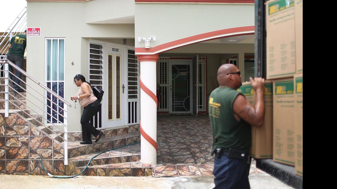 
Yessenia Puente (C) walks up the stairs to her apartment as movers from La Rosa del Monte moving company pack up her apartment as she prepares to move to Orlando, Florida. Puente joins a mass exodus of people fleeing the island due to increasing economic hardships and a financial crisis that has resulted in an estimated $72 billion public debt for the Puerto Rican government, which the governor has said is unpayable. The workers for the moving company, La Rosa del Monte, said that she is number 1465 that the company has packed for Orlando since the beginning of the year.
