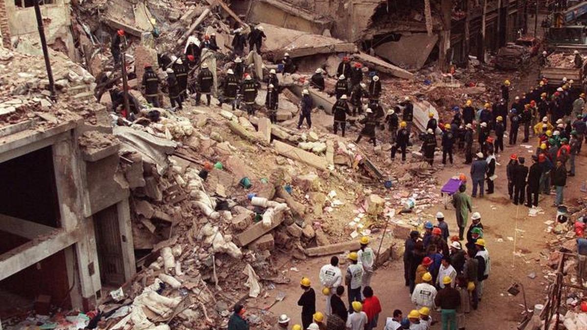 
In this July 18, 1994 file photo, firefighters and rescue workers search through the rubble of the Argentine-Israeli Mutual Association community center, after a car bomb rocked the building in downtown Buenos Aires, Argentina. On Thursday, Aug. 6, 2015, 7,689 days since the 1994 attack on the Argentine Israelite Mutual Association, former President Carlos Menem, a former top judge and several others will go on trial for allegedly derailing the investigation into the attack. No one has been convicted in the South American country’s worst terrorist attack, which many Argentines believe has come to symbolize an inept and corrupt justice system that operates at the whims of politicians and can be bought off. 
