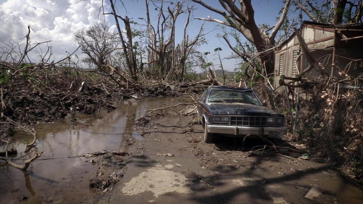 Puddles of water and mud alongside a washed out car litter the front of Hernan Cabrera's house in the Media Luna neighborhood of Toa Baja, Puerto Rico.