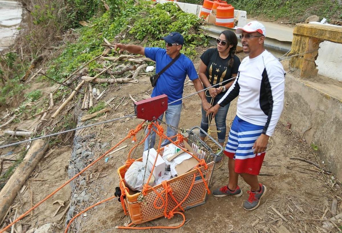 Good Samaritans from the town Isabela, brothers Saul Aldarondo, right, and Luis Aldarondo, alongside Mary Lopez fill a shopping cart with necessities for the community of Rio Abajo during the aftermath of Hurricane Maria on Friday, October 27, 2017 in Puerto Rico.