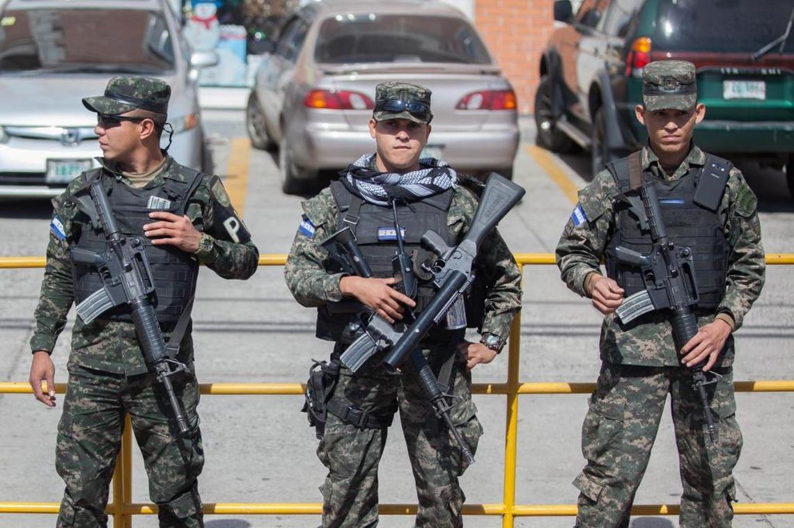 Armed members of the Honduran Military Police stand alongside the road as protesters march on Dec. 10, 2017.