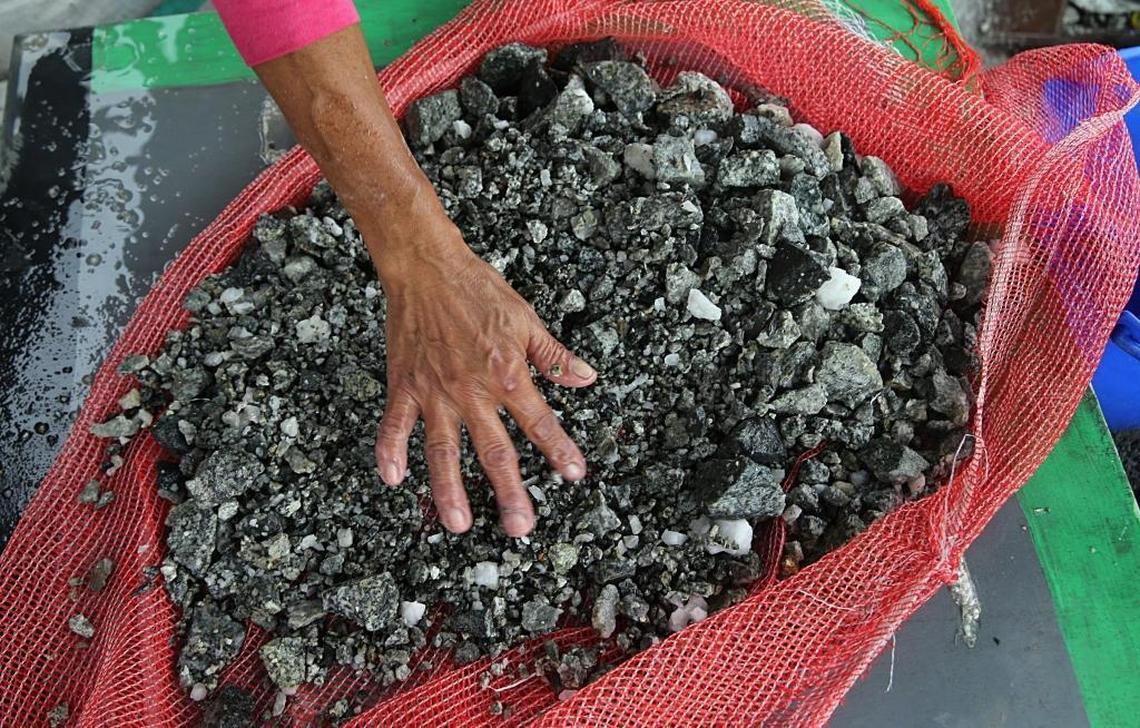 Doris Fonegra, one of a group of workers — mostly women — called ‘chatarreros,’ reaches into a pile of rocks, looking for particles of gold extracted from Las Brisas independent gold mine, located near the town of Segovia in Colombia’s Antioquia department.