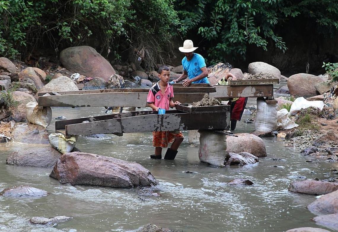 Workers — among them children — search for gold amid fine sand contained in the water dumped into a river known as Cianurada, ‘cyanide-filled river.’ The water was discharged from the Gran Colombia Gold Corp. factory, located in the town of Segovia, in Colombia’s Antioquia department.
