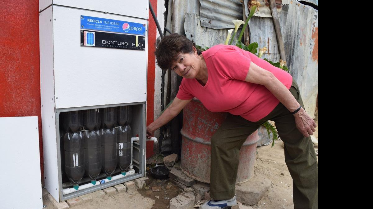 
Ana Morales near Bogota, Colombia opens the tap on her Ekomuro — a rainwater cistern made out of discarded 3-liter bottles. 
