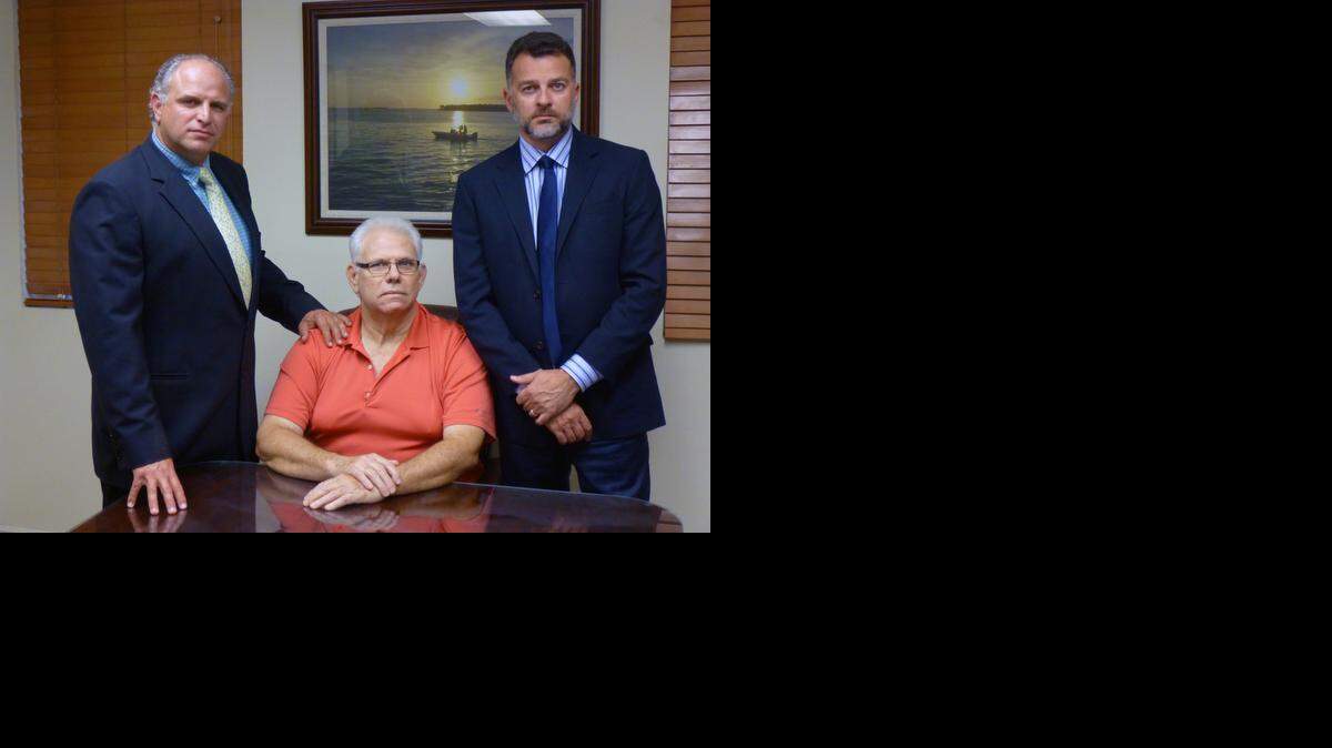 
Antonio Caballero (seated) was recently awarded $191 million by Florida courts for the kidnapping and murder of his father in Colombia in 1999. Beside him are his legal team, Joseph Zumpano (left) and Leon Patricios.
