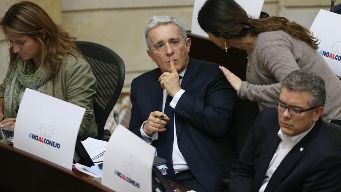 Colombia's former president and opposition Senator Alvaro Uribe sits at his desk covered in signs that say in Spanish "No to the rabbit," a local way to refer to cheating, in the Senate in Bogota, Colombia, Thursday, Nov. 24, 2016, the day the government and Revolutionary Armed Forces of Colombia, FARC, signed a revised peace pact. Uribe's party may boycott the congressional debate on ratifying the agreement, calling the new peace deal unconstitutional after it was first rejected in a referendum last month.