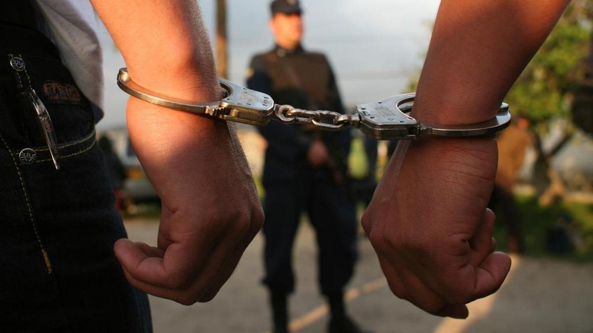 In this March 11, 2009, photo, two handcuffed rebels of the Revolutionary Armed Forces of Colombia, FARC, walk back to their cells after attending a ceremony where they were graduated as "peacemakers" after they renounced the rebel group.