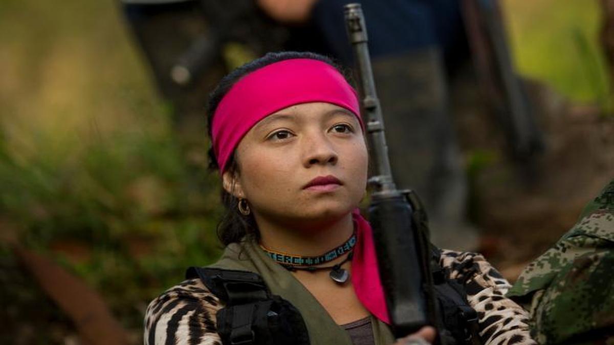 In this Jan. 4, 2016 photo, Yesenia, a 19-year-old rebel soldier for FARC, listens to a commander speak on the peace negotiations between the rebels and the Colombian government, in a hidden camp in the northwest Andes of Colombia. Now peace is within reach as talks between the guerrillas and the government near conclusion in Cuba, and for the first time the rebels are thinking about a future outside this jungle hideout.