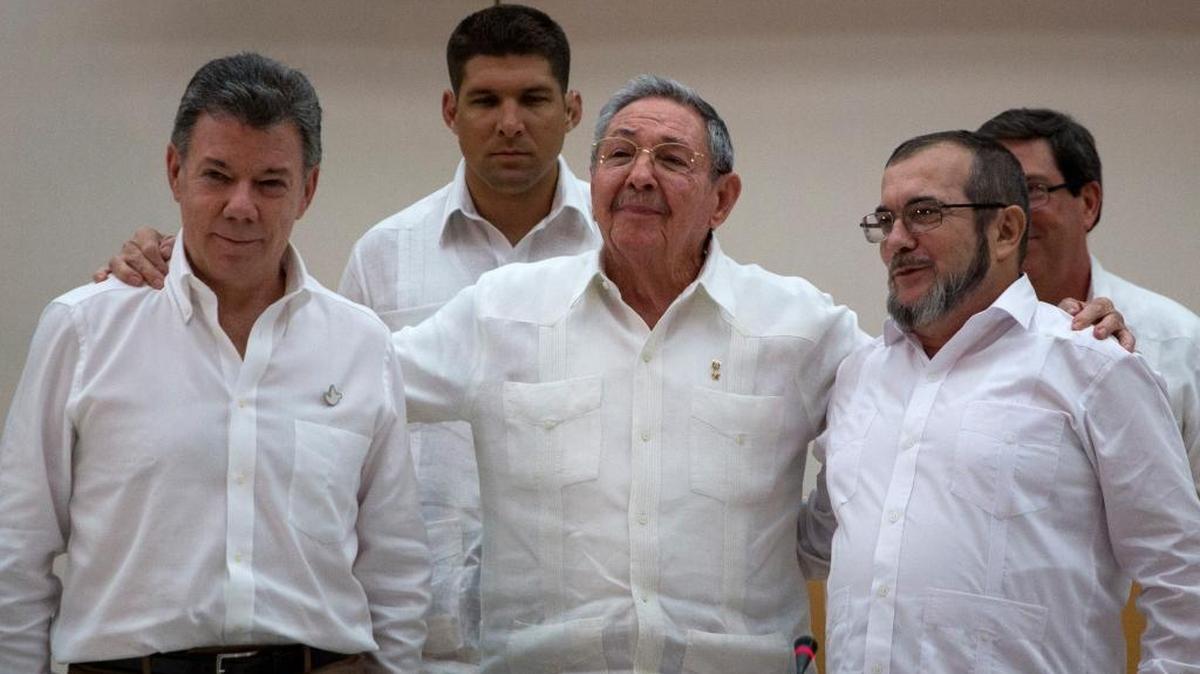 
Cuba's President Raul Castro, center, embraces Colombian President Juan Manuel Santos, left, and Commander the Revolutionary Armed Forces of Colombia or FARC, Timoleon Jimenez , in Havana, Cuba, Wednesday, Sept. 23, 2015. In a joint statement, Santos and the FARC said they have overcome the last significant obstacle to a peace deal by settling on a formula to compensate victims and punish belligerents for human rights abuses. 
